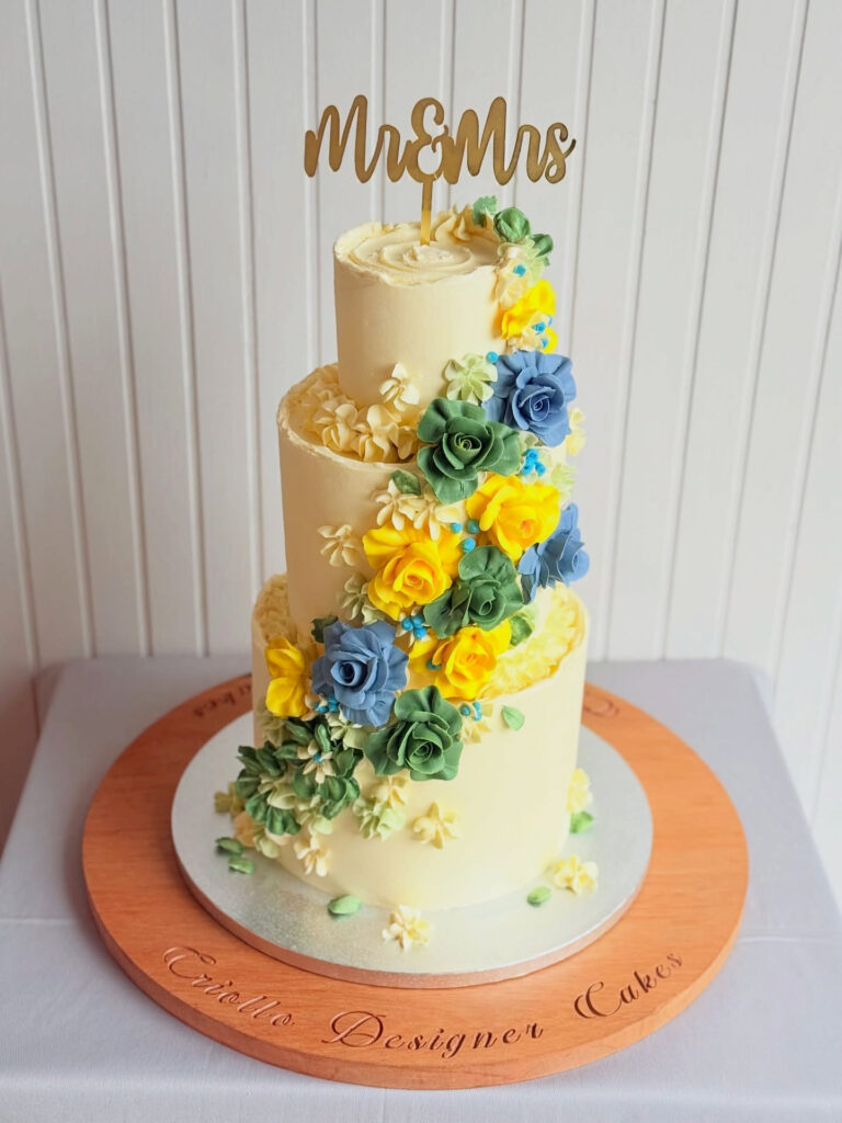 Blue and Yellow Floral Cascade Three-Tier Wedding Cake by Criollo Designer Cakes in Dunedin, Otago