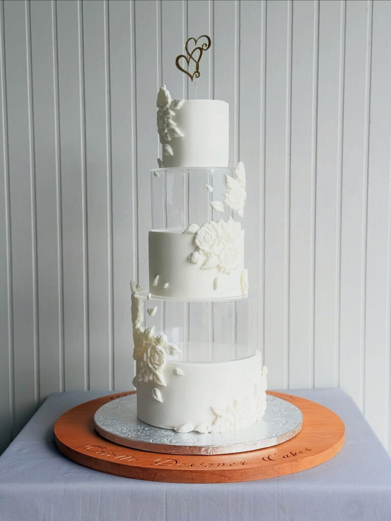 White Floral Clear-Spacer Four-Tier Wedding Cake by Criollo Designer Cakes in Dunedin, Otago